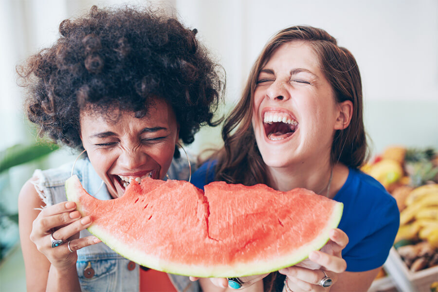 Ženy spolu jedí kousek melounu a smějí se
